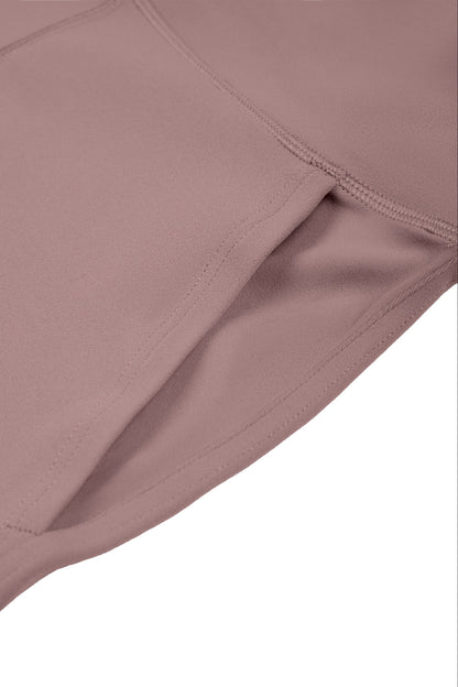 Close-up detail of a dusty rose or mauve-colored athletic fabric, showing the texture and stitching against a plain white background.