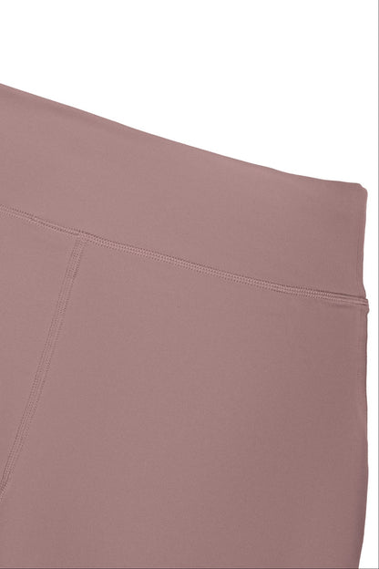 Close-up of a dusty rose or mauve-colored athletic leggings waistband and upper leg section against a plain white background.
