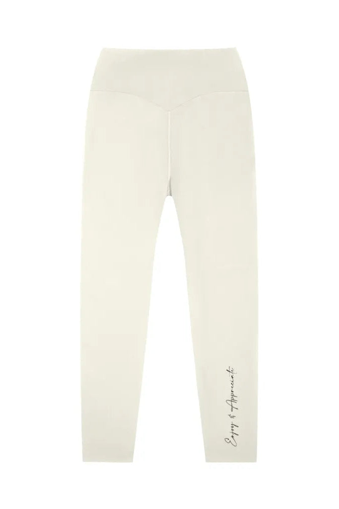 Cream-colored high-waisted seamless activewear leggings with a subtle cursive script on the lower leg
