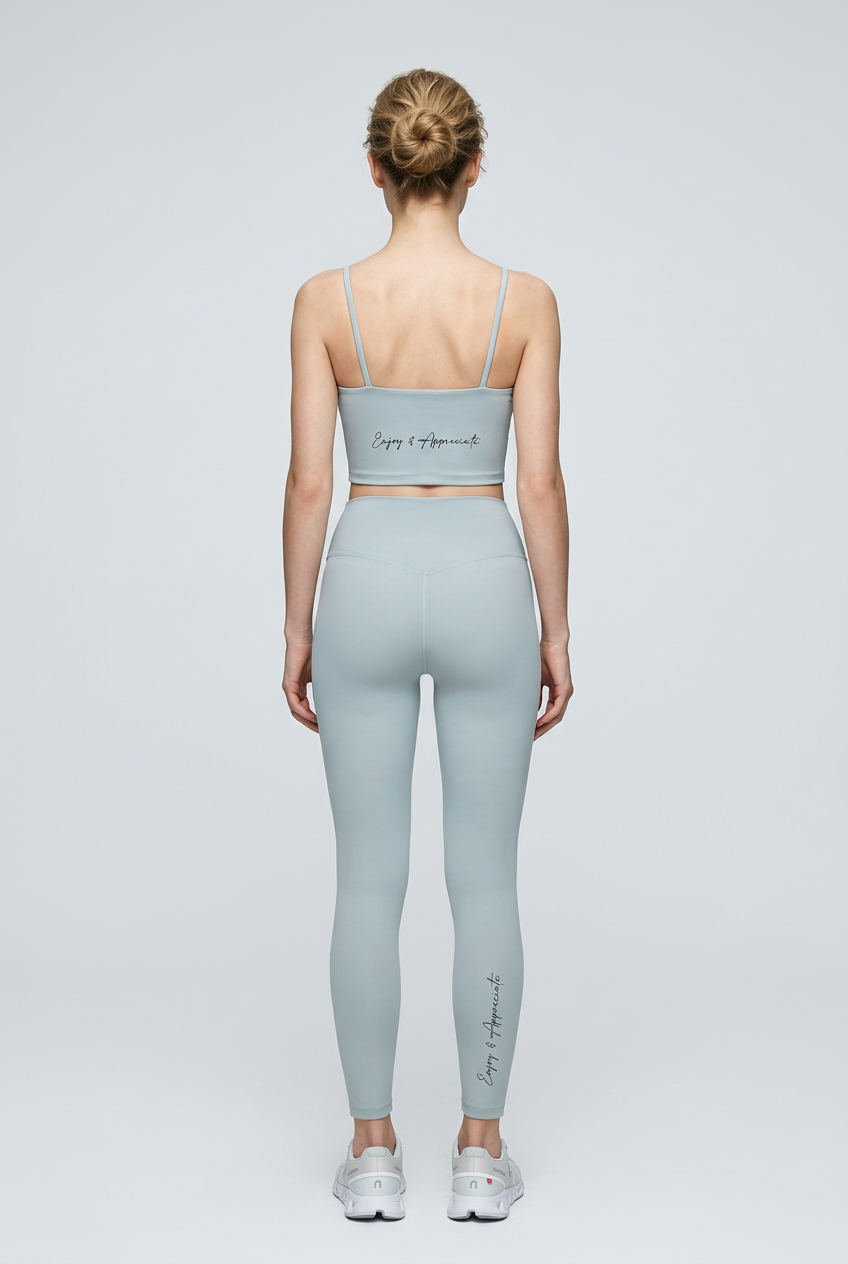 A light blue high-waisted seamless activewear leggings set with thin strap crop top featuring enjoy and appreciate script