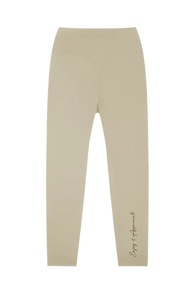 Beige high-waisted seamless activewear leggings with subtle cursive script detail on the lower leg